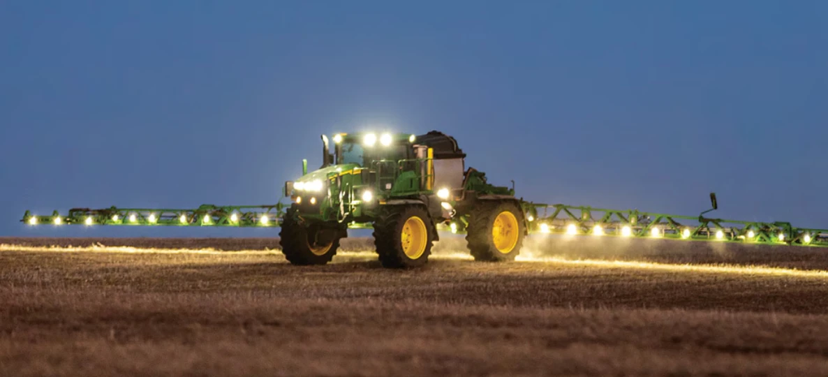 A self-driving sprayer working a field at night under its lights